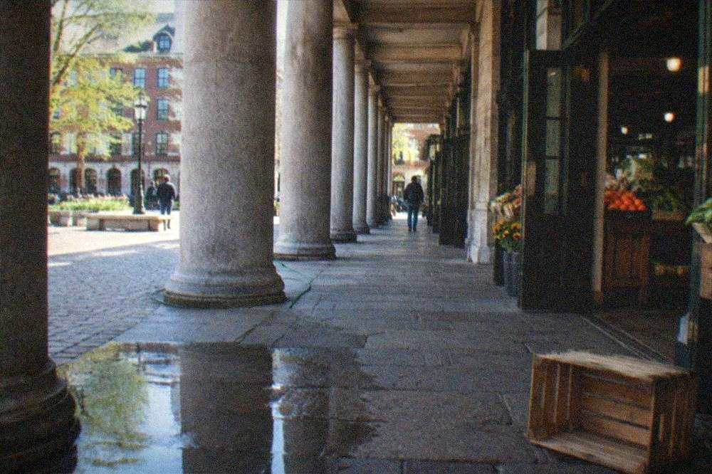 Granite columns of a historic market hall with food stalls visible through the open doors