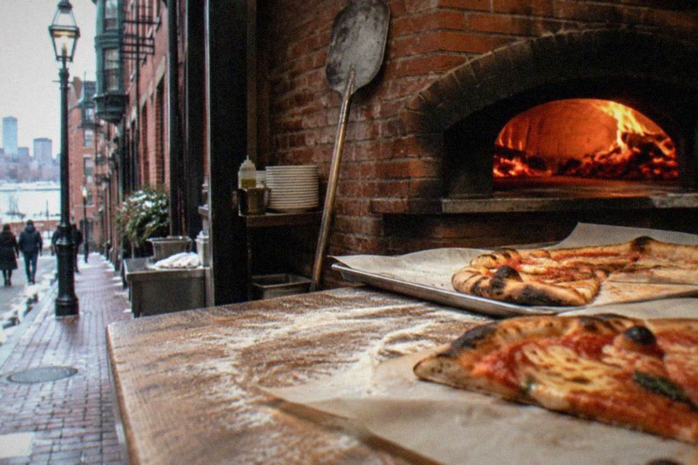 Slices of pizza fresh from a brick oven on a wooden counter in a pizzeria