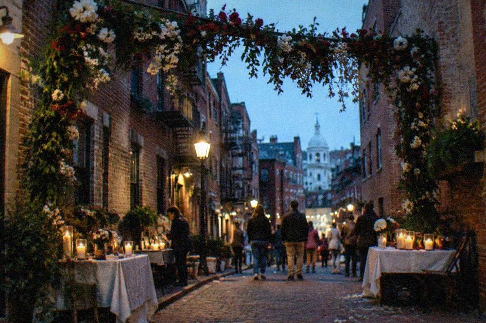 Decorated festival archway and vendor stalls on a Boston street at dusk