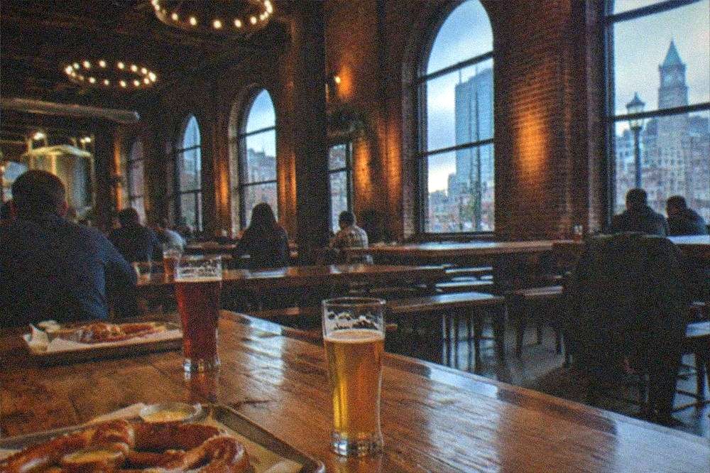 Pretzels and beer glasses on a communal table inside a brewery hall