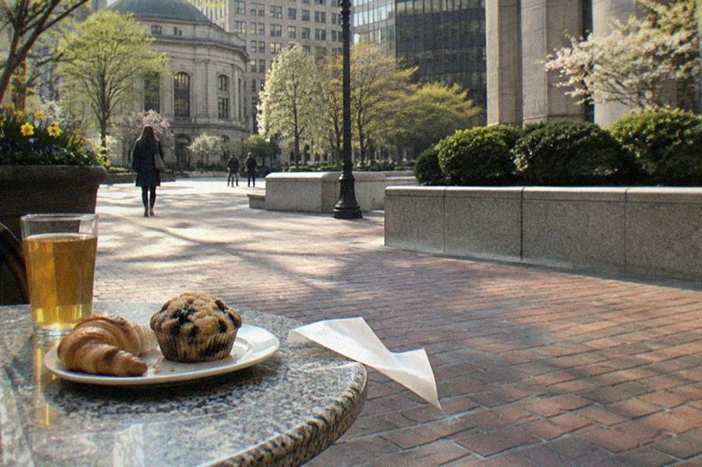 a plate of pastries and a glass of cider on an outdoor cafe table in Boston