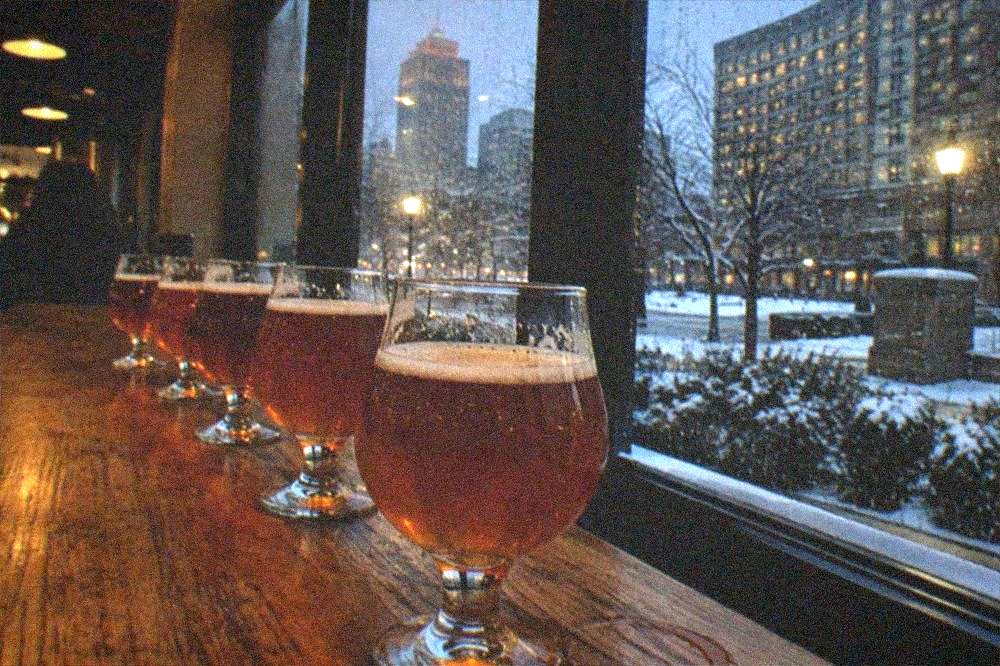 Glasses of craft beer lined up on a wooden bar in a brewery taproom
