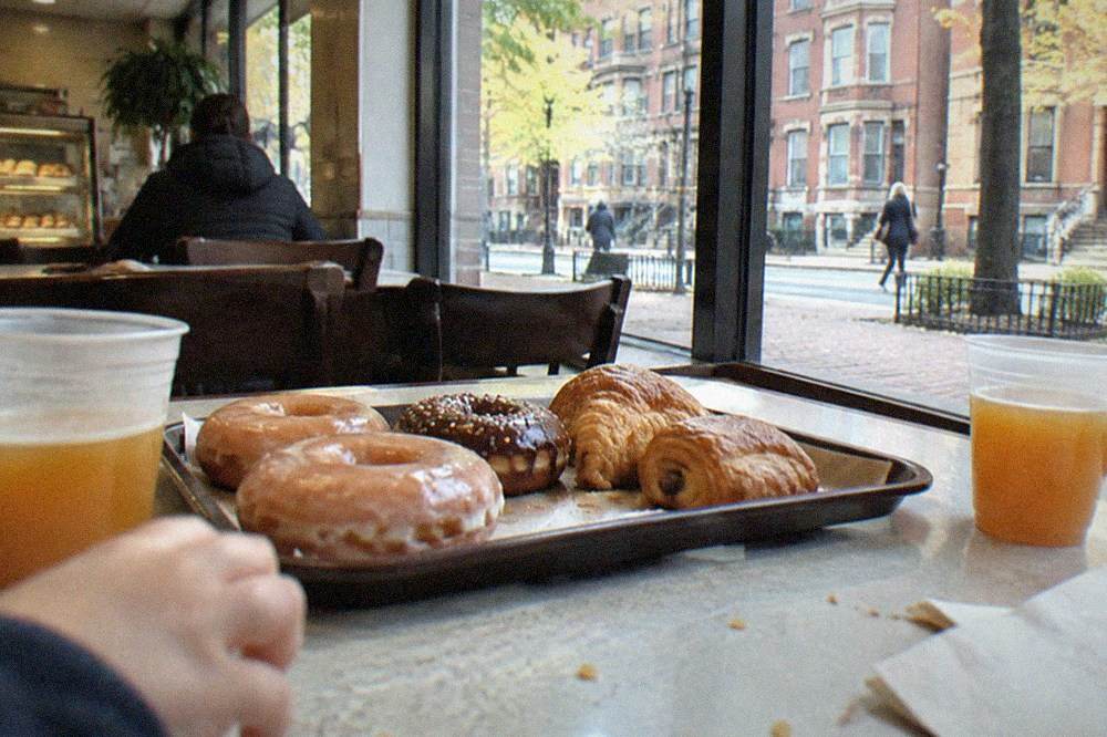 A family table with donuts, cider, and pastries at a downtown Boston bakery