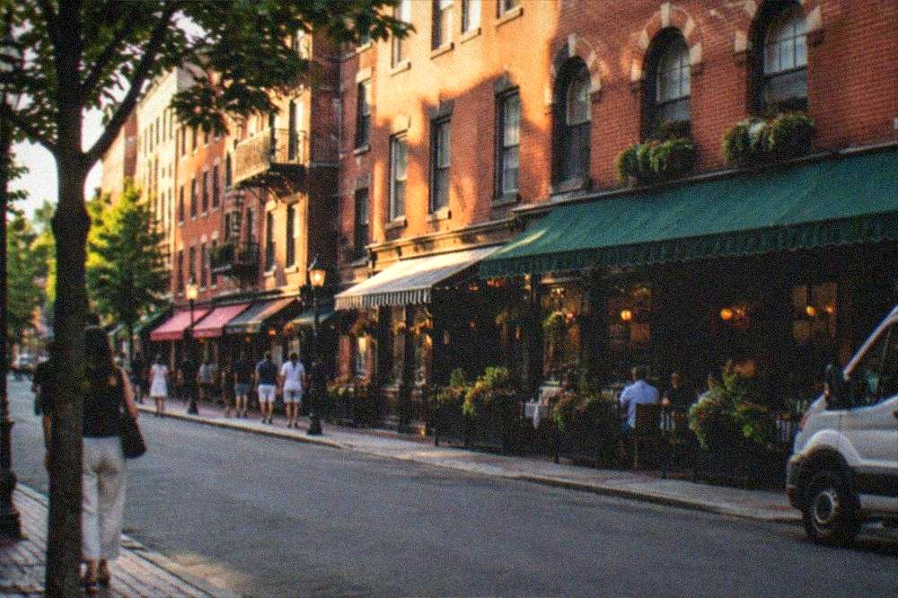 Historic brick storefronts along Hanover Street with Italian bakery signage in daylight
