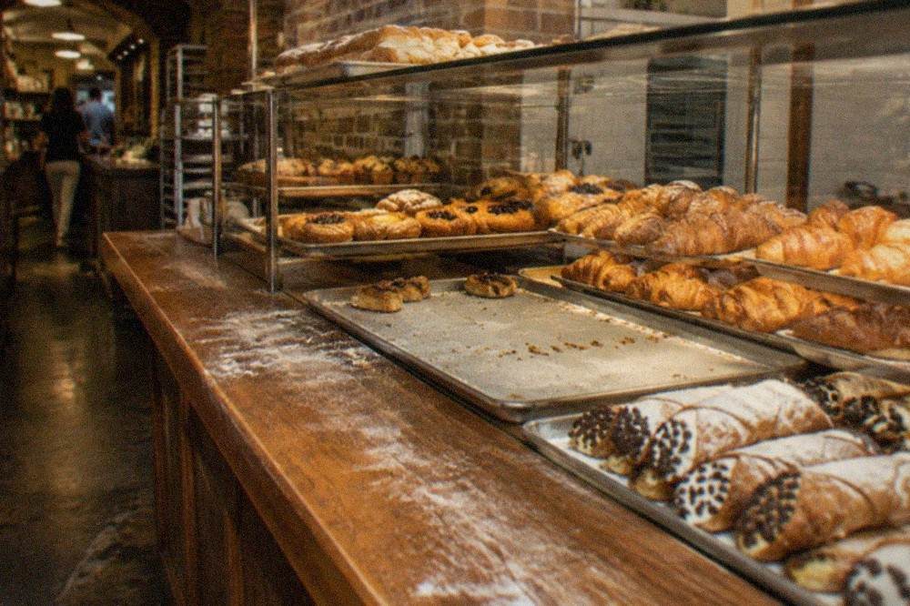 A wooden counter displaying rows of pastries in a Boston bakery