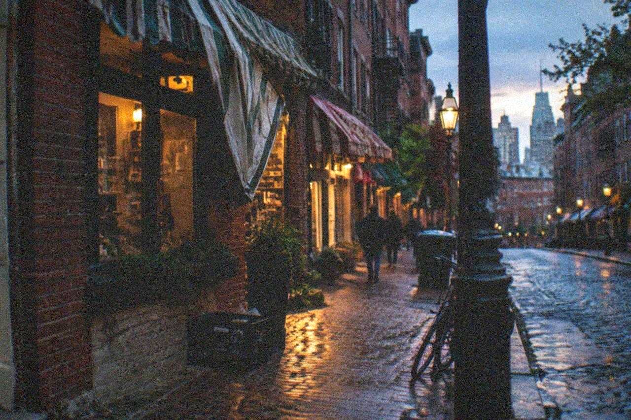 Row of old brick storefronts and striped awnings along a narrow North End street