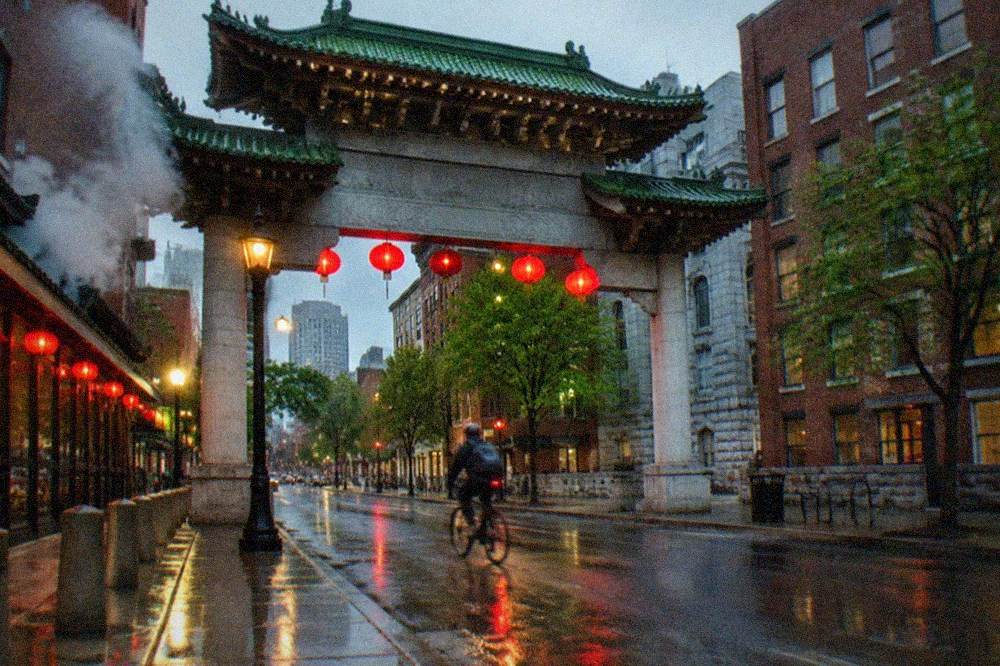 Chinatown gateway arch over a busy street with restaurant signs in Chinese and English