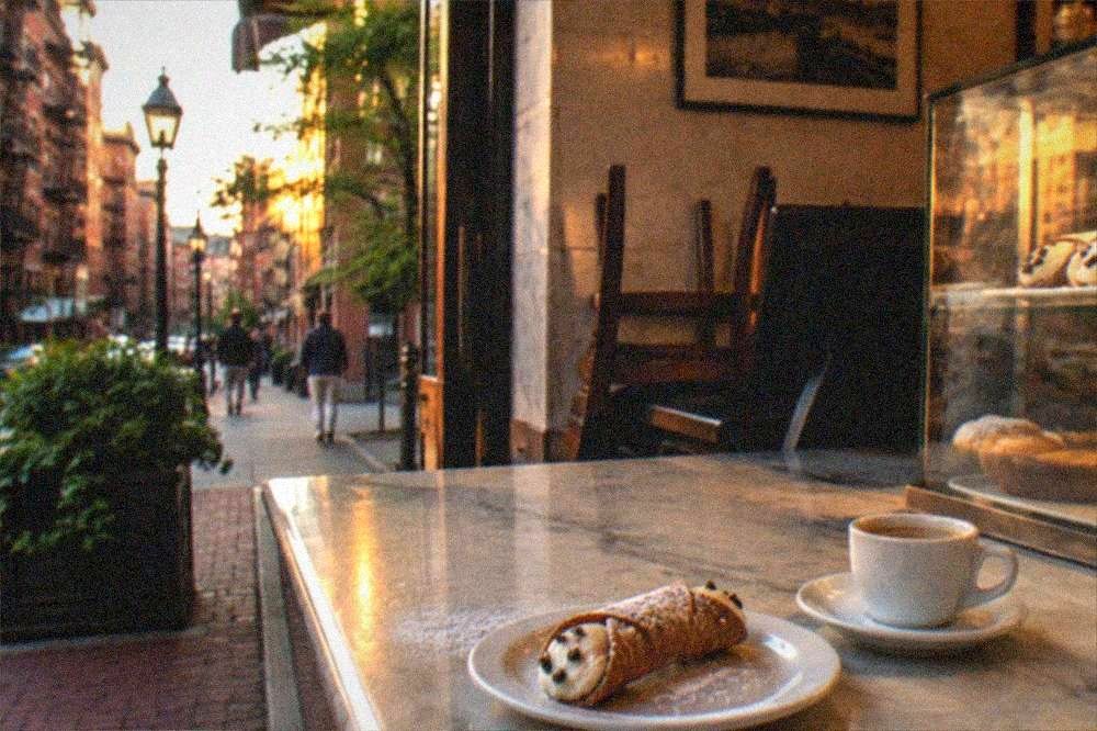 Cannoli and espresso arranged on a marble bakery counter