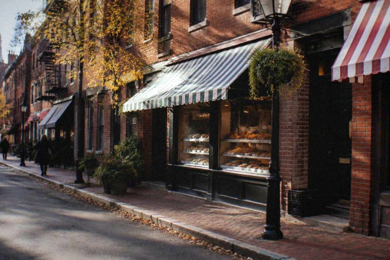 Hanover Street in the North End with bakery storefronts and striped awnings along the sidewalk
