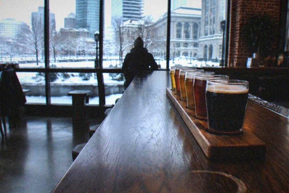 Row of beer glasses lined up on a wooden brewery tasting bar