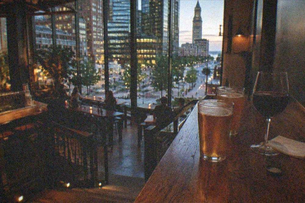 Glasses of beer and wine on a wooden counter in an evening taproom