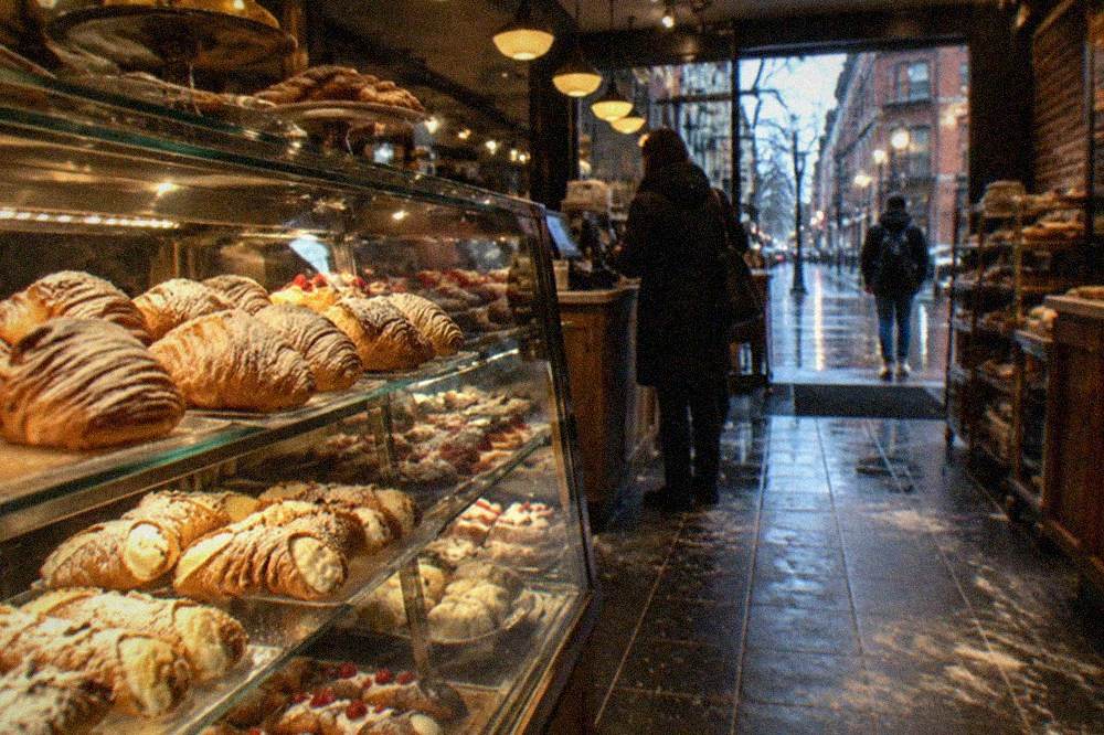 Old Italian bakery counter with pastry cases and hanging café lights