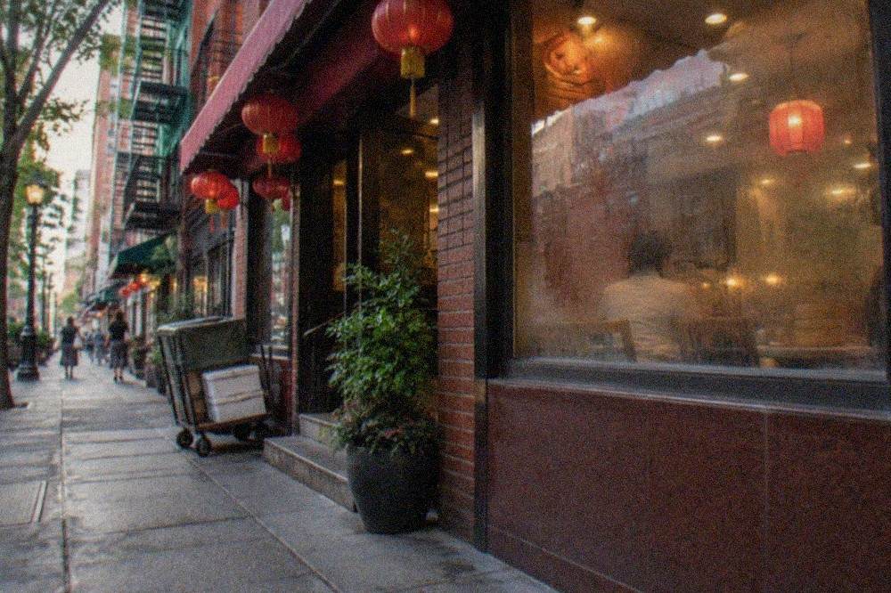 Colorful restaurant awnings and hanging signs on a busy Chinatown street corner