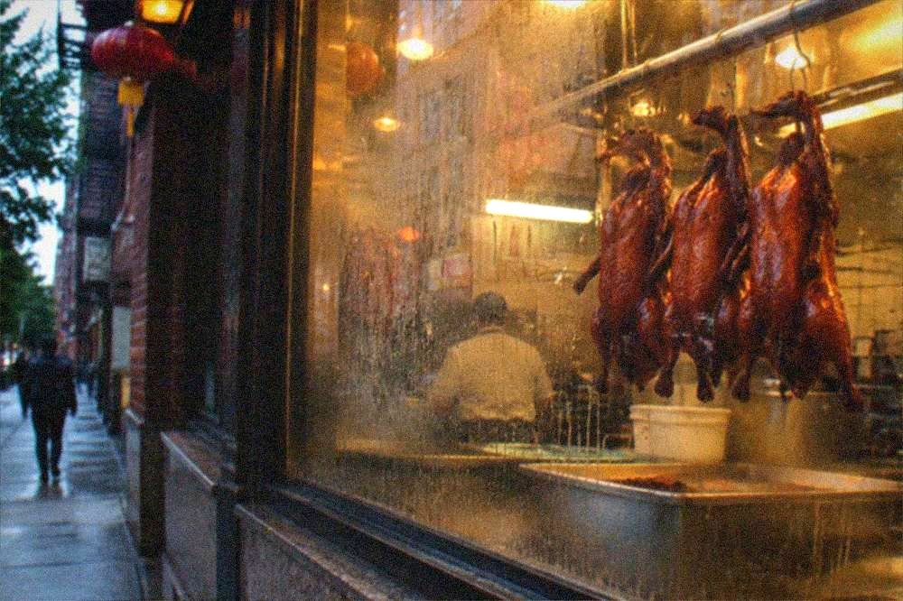 Window display of roast ducks hanging in a Chinatown restaurant