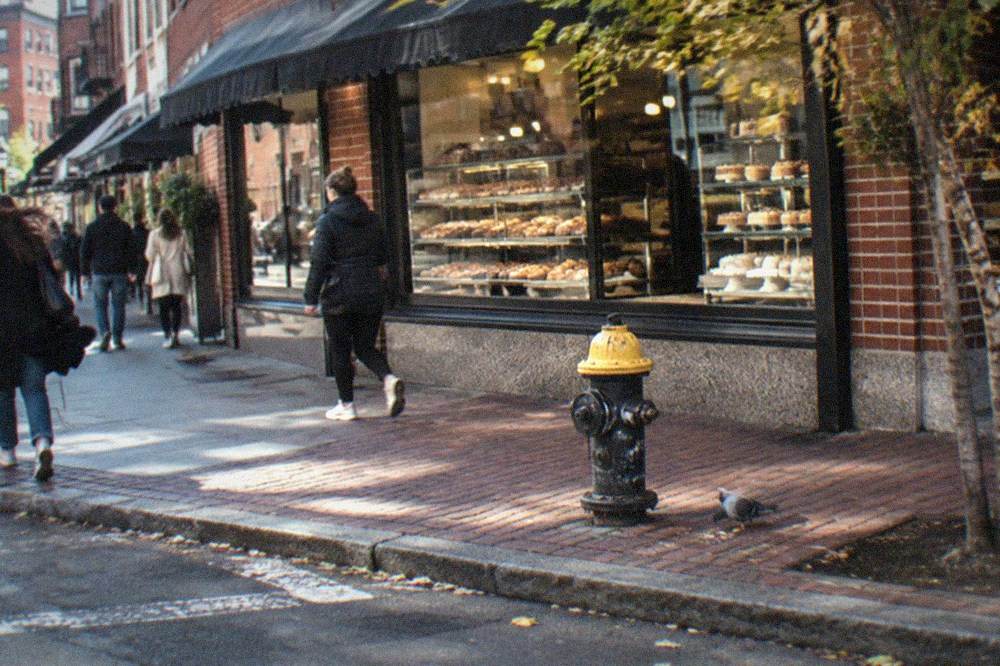 Busy Hanover Street with Italian restaurants, awnings and pastry shops on both sides