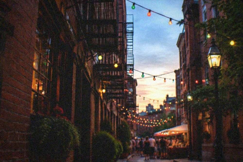 Decorated North End street with festival lights and banners over the sidewalk