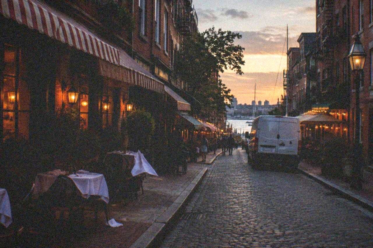 Row of old brick Italian restaurants and bakeries along a narrow North End street