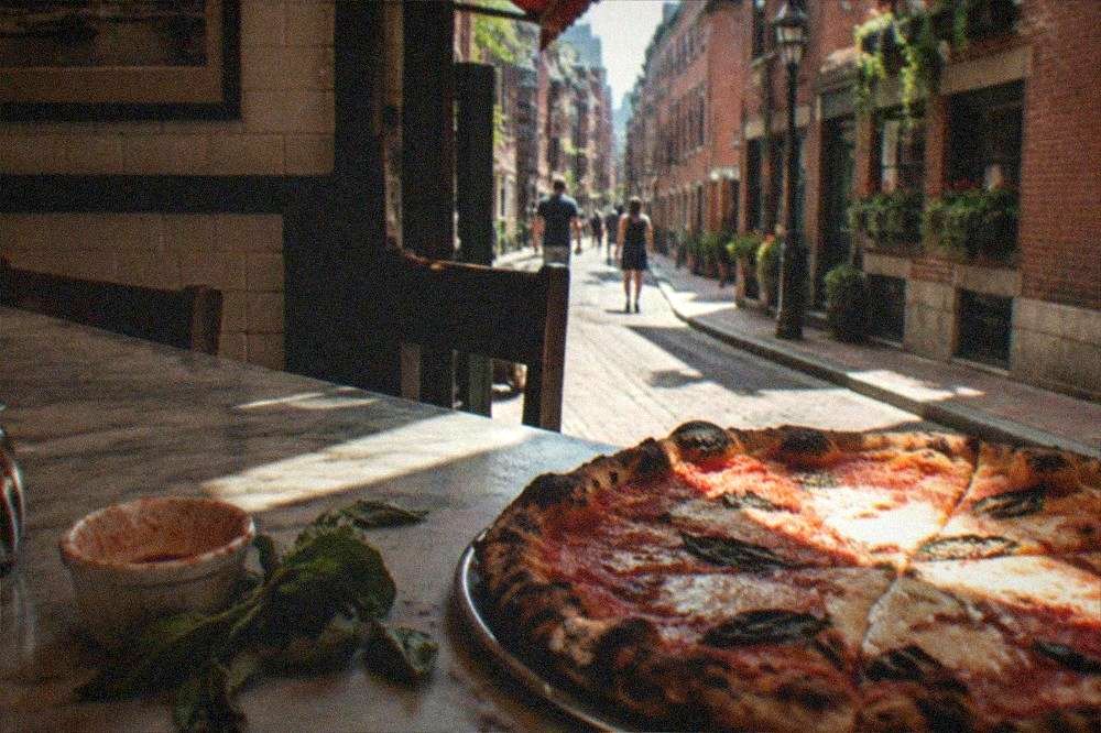 A freshly baked pizza on a marble counter in a small Italian shop