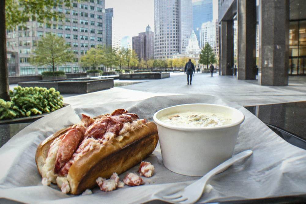 Market food counter with lobster roll and cup of chowder on a tray
